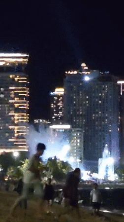 Southeast Asian night market with beach, street food, and costumed performers