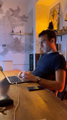 Man works thoughtfully at laptop in Buenos Aires cafe