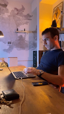 Man works thoughtfully at laptop in Buenos Aires cafe