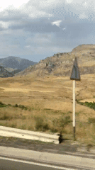 Road trip through dry hills and rocky mountain terrain.