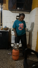 Woman cooking with portable gas burner in kitchen