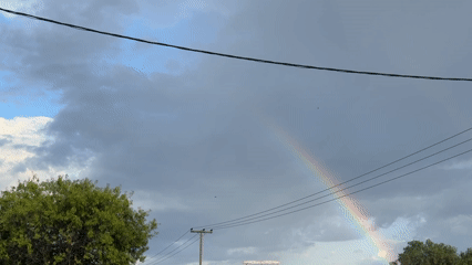 Rainbow appears over Γερακινή, Greece amid cloudy afternoon skies
