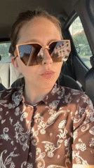 Woman records car selfies in Podgorica on sunny afternoon