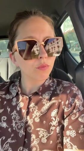 Woman records car selfies in Podgorica on sunny afternoon