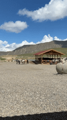 Mountain parking area with saddled boulder and shelter documented