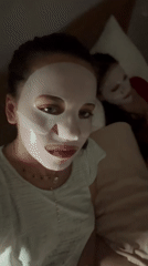 Two women enjoy facial masks during evening skincare routine