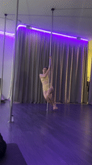 Women participate in pole fitness class at LED-lit studio