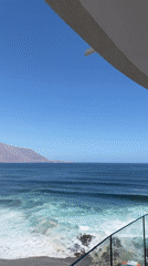 Coastal scene filmed from elevated balcony on sunny day