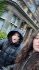 Two women walk together outside brick building in Hull