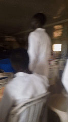Religious gathering documented in community hall, attendees in white