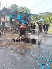 Costumed figure draws crowd in puddle in Pereng