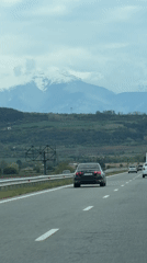 Highway traffic filmed near Bulgarian mountains