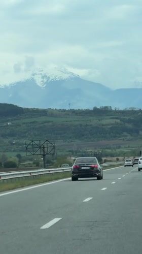 Highway traffic filmed near Bulgarian mountains