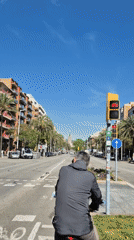 Morning cyclist waits at Barcelona intersection near Sagrada Familia