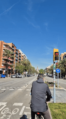 Morning cyclist waits at Barcelona intersection near Sagrada Familia