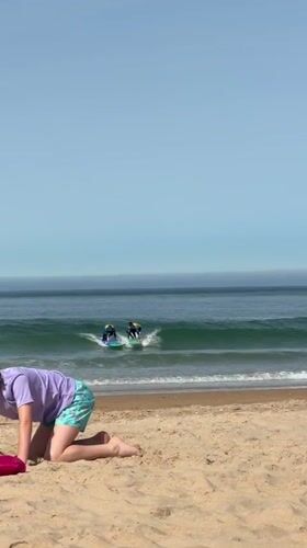 Surf and beach activity at Costa da Caparica on a sunny morning