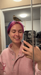 Woman Takes Bathroom Selfies With Bird Perched On Head