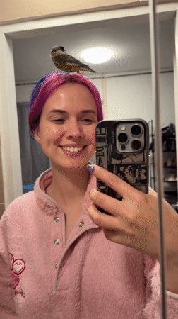 Woman Takes Bathroom Selfies With Bird Perched On Head