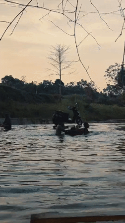 Woman sits on moss-covered rock in Indonesian waterway