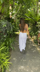 Woman walks through tropical resort area in Thailand