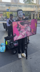 Masked protester displays fish processing footage on Burnaby sidewalk