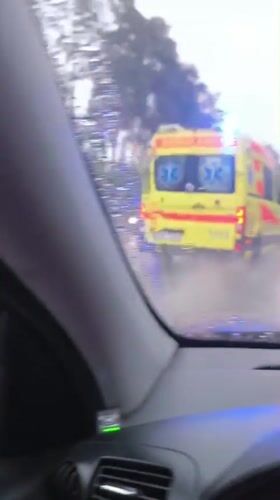 Driver records ambulance passing during rainy weather in Latvia