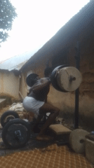 Man conducts outdoor weightlifting session with improvised equipment