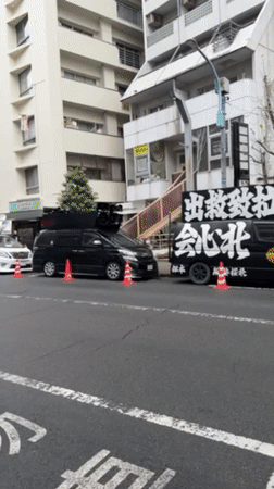 Vehicles parked with traffic cones on Suginami City street