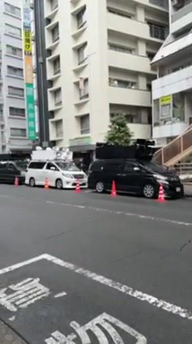 Vehicles parked with traffic cones on Suginami City street
