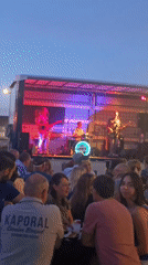 Live band performs outdoor evening concert with crowd dining