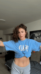 Woman does stretches in hallway wearing Miami shirt