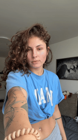 Woman does stretches in hallway wearing Miami shirt