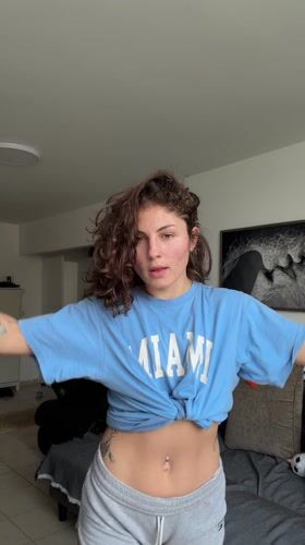 Woman does stretches in hallway wearing Miami shirt
