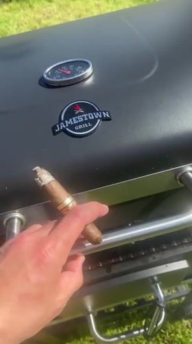 Person grills food while smoking cigar in Dimchevo, Bulgaria