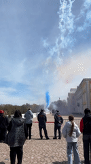 Tourists watch colorful smoke display at Russia's Peterhof Palace