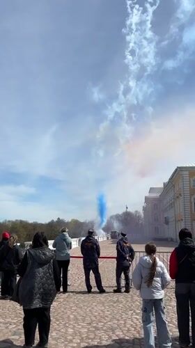 Tourists watch colorful smoke display at Russia's Peterhof Palace
