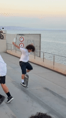 Young men skateboard near Barcelona waterfront during sunset session