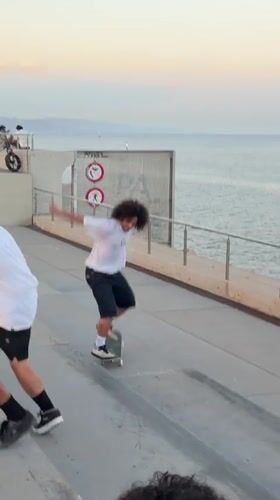 Young men skateboard near Barcelona waterfront during sunset session