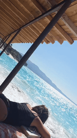Relaxing on a wooden deck above turquoise coastal waters