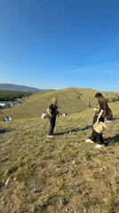 Outdoor festival with Cyrillic-bannered stage and hillside crowd