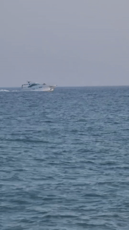 Busy afternoon on Quarteira beach, boats offshore