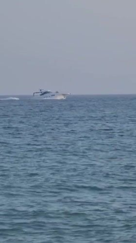 Busy afternoon on Quarteira beach, boats offshore