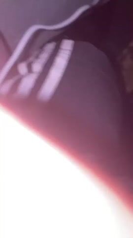 The video begins with an abstract shot of a pinkish light bleeding into white. This transitions to complete blackness for two seconds. Then, a dimly lit scene appears, showing a dark patterned fabric and a hint of a gray surface. The video then shows a close-up of dark fabric with white stripes, possibly part of a garment, next to a gray concrete wall with two white electrical outlets and a white cord. The overall lighting suggests it is nighttime or an indoor, dimly lit environment.