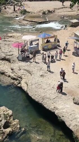Tourist activity captured along historic Neretva River in Mostar