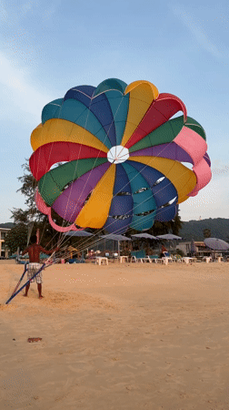 Tourists photograph sunset at Karon Beach, Thailand