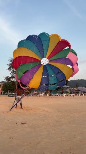 Tourists photograph sunset at Karon Beach, Thailand