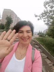 Woman waves at camera in Krasnoyarsk street scene