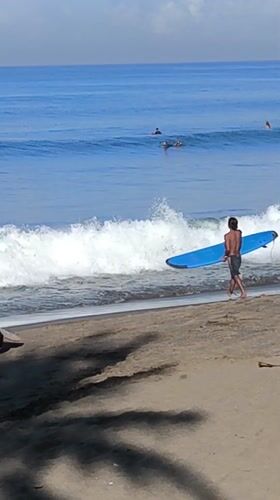 Surfers gather at Dalung beach on sunny evening