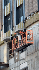 Construction workers on suspended platform in Moscow building project