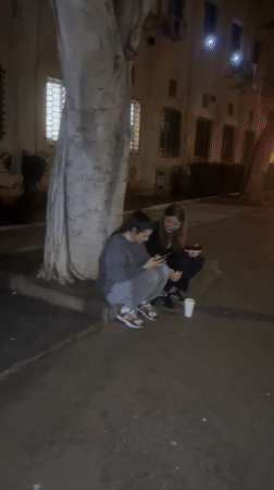 Nighttime gathering in Haifa involves filling cooler with drinks